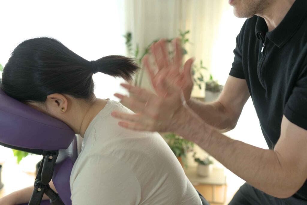 Photo capturing therapist's rapid hand tapotement massage technique.